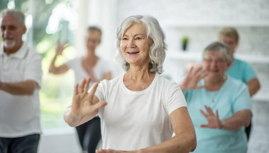 Retirement Community in Boca Raton, FL | Sunscape Boca Raton A group of seniors spend an afternoon indoors in a health center. They are doing group tai chi together.