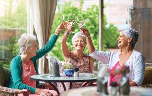 Senior Living Community Grand Opening Thursday May 4 Older woman clinking wine glasses-Sunscape Boca Raton Grand Opening