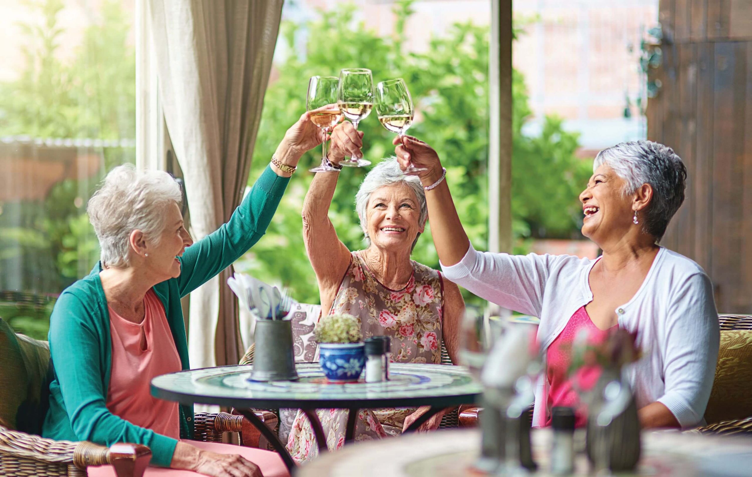 Senior Living Community Grand Opening on May 4, 2023 Older woman clinking wine glasses-Sunscape Boca Raton Grand Opening