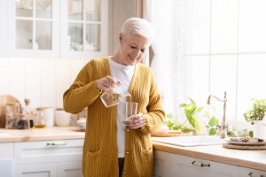 Senior Woman Pouring Glass of Water_Healthy Aging