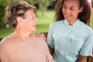 Senior Woman Sits with Caregiver_Senior Living in Boca Raton