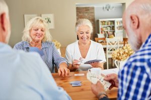 Group of Smiling Seniors Play Cards_Senior Living in Boca Raton