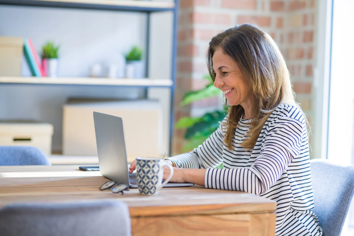 Smiling Mature Woman Looking at Laptop_Boca Raton Senior Living