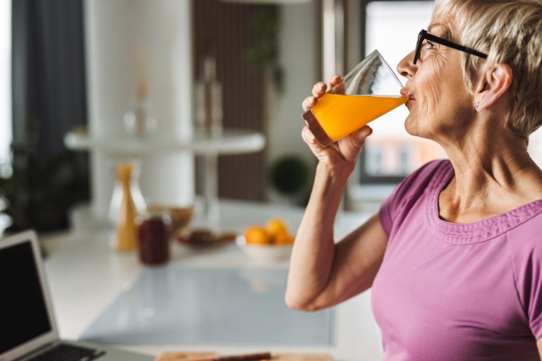 Ways to Boost Your Immune System for a Vibrant Life Senior Woman Drinking Orange Juice_Retirement Community in Boca Raton