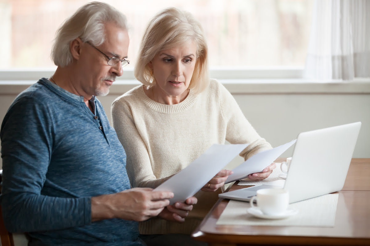 Senior Living Resources | Sunscape Boca Raton Senior Couple at Table Comparing Costs