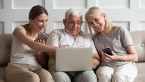 Older adults researching senior living options online with daughter.
