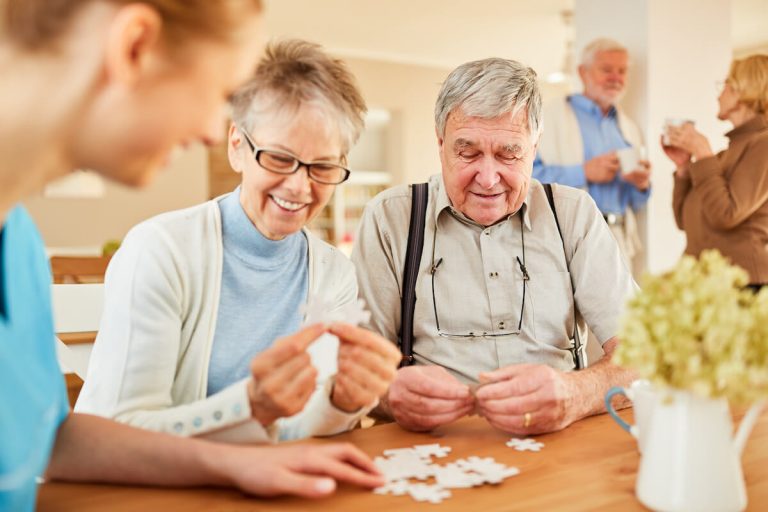 Assisted Living vs. Memory Care: What Are the Differences? Happy seniors putting a puzzle together