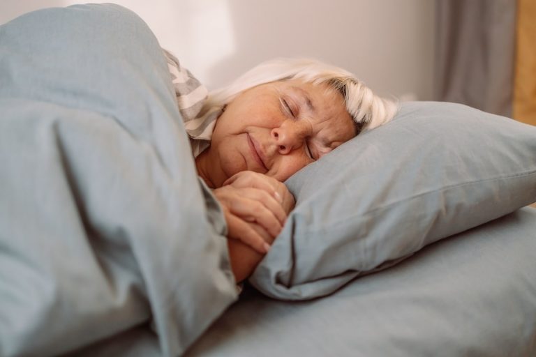 How Sleep Changes with Age & How to Implement Better Habits Older woman sleeping.