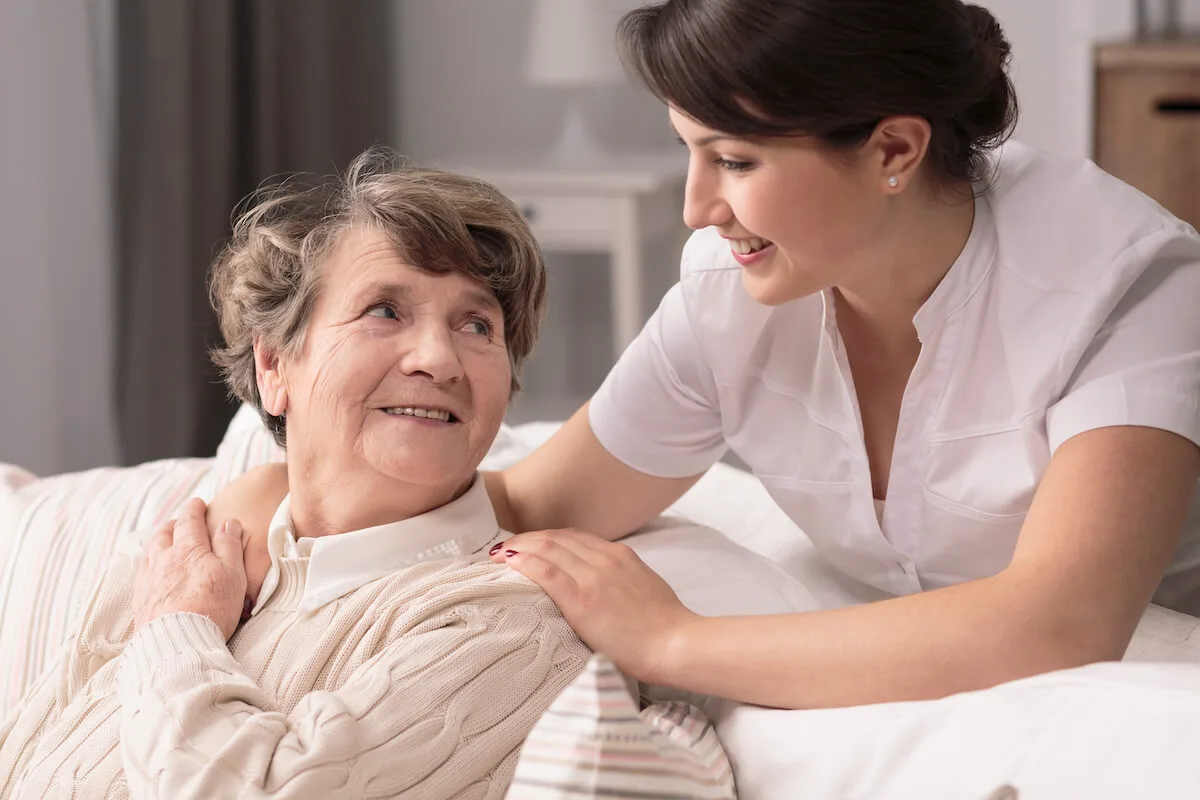 Caregiver comforting an older woman.