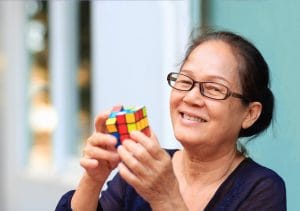 Older woman solving a Rubik's cube