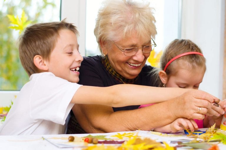 Create a New Year Vision Board with Your Grandchildren Grandmother crafting a vision board with grandchildren.