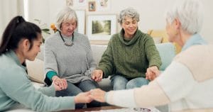 Group of older women praying together