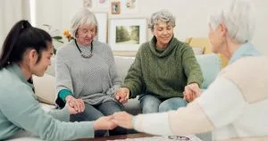Group of older women praying together