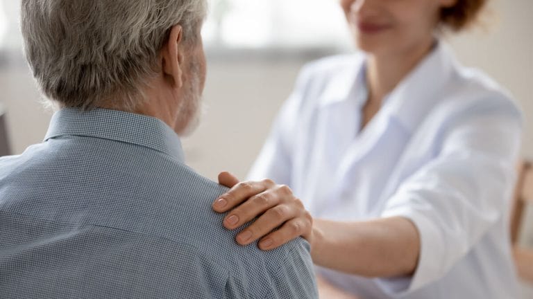 Why Do Seniors Resist Assisted Living? Caregiver touching a senior's shoulder