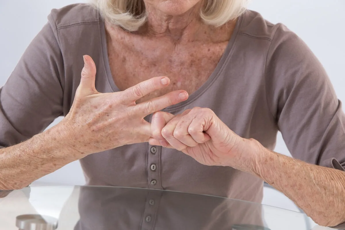 Older woman with arthritis stretching her finger