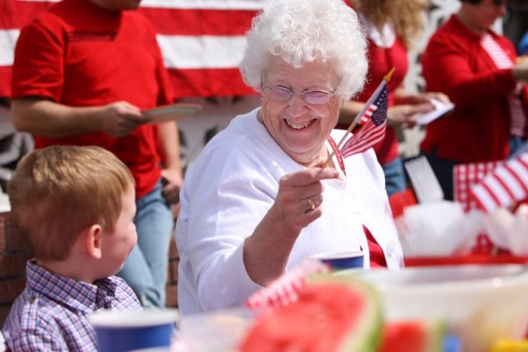 Celebrating the 4th of July with Senior Safety in Mind Smiling older woman celebrating 4th of July with her grandson