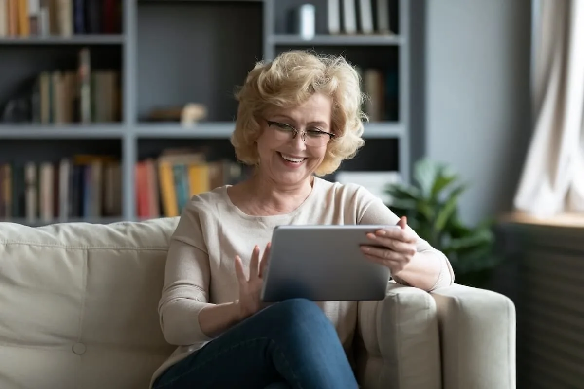 Older woman happily using a tablet