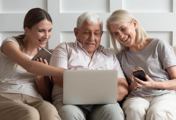 Older adults researching senior living options online with daughter.