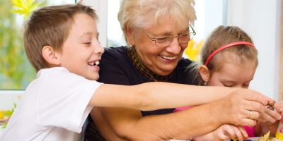 Grandmother crafting a vision board with grandchildren.